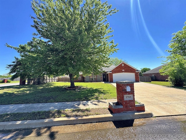 view of property hidden behind natural elements featuring brick siding, fence, a garage, concrete driveway, and a front yard