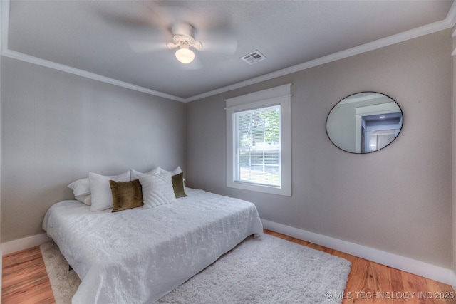bedroom with baseboards, crown molding, and visible vents