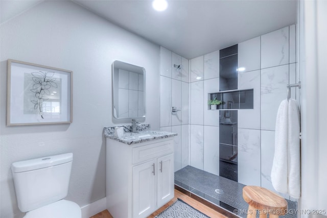 full bath featuring walk in shower, toilet, wood finished floors, and vanity