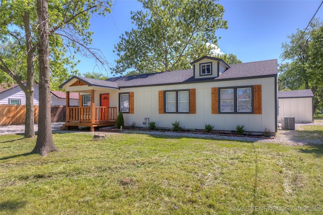 ranch-style house with central AC unit, a deck, a shingled roof, and board and batten siding
