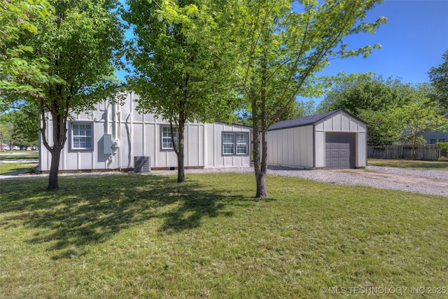 ranch-style house with fence, an outdoor structure, a front yard, driveway, and a detached garage