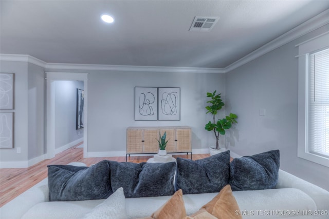 living room featuring baseboards, a wealth of natural light, visible vents, and wood finished floors