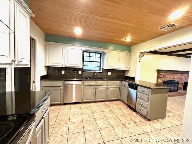 kitchen featuring a peninsula, visible vents, a sink, and dishwasher