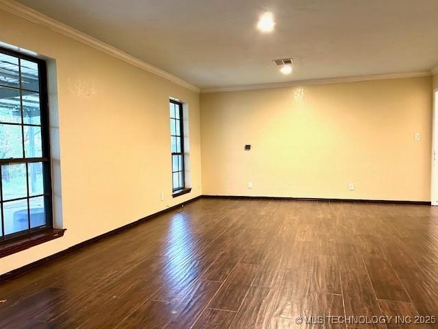spare room with crown molding, a wealth of natural light, and wood finished floors