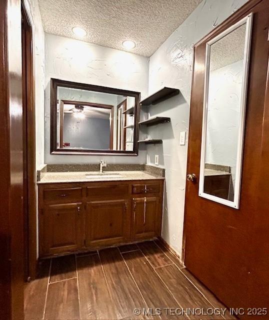 bathroom featuring vanity, a textured ceiling, and wood finished floors