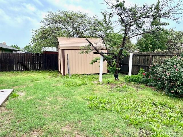 view of yard with an outdoor structure, a shed, and a fenced backyard