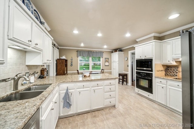 4721 S Irvington Pl, Tulsa, OK 74135 - kitchen with black appliances, a peninsula, ornamental molding, white cabinets, and recessed lighting