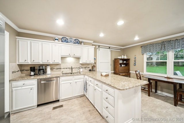 4721 S Irvington Pl, Tulsa, OK 74135 - kitchen with dishwasher, crown molding, white cabinetry, a barn door, and a peninsula
