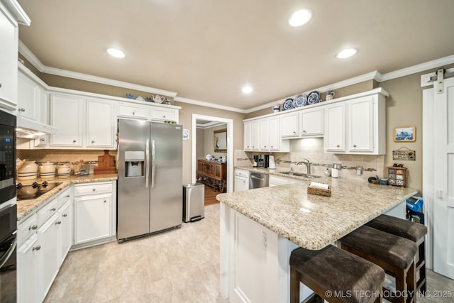 4721 S Irvington Pl, Tulsa, OK 74135 - kitchen with appliances with stainless steel finishes, a peninsula, white cabinetry, a breakfast bar, and backsplash