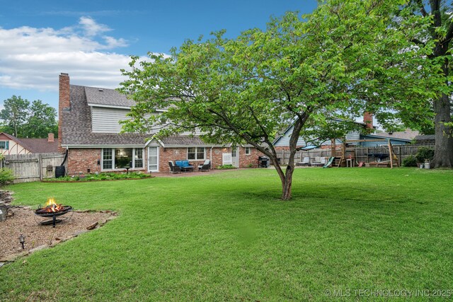 4721 S Irvington Pl, Tulsa, OK 74135 - fenced backyard featuring a fire pit, a patio, and a playground