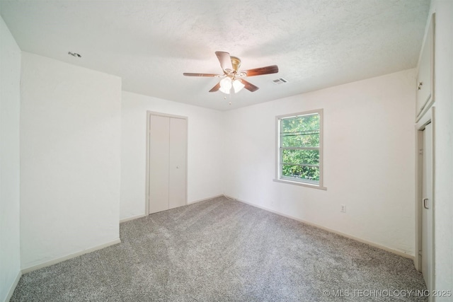 unfurnished bedroom featuring ceiling fan, carpet flooring, a closet, and visible vents