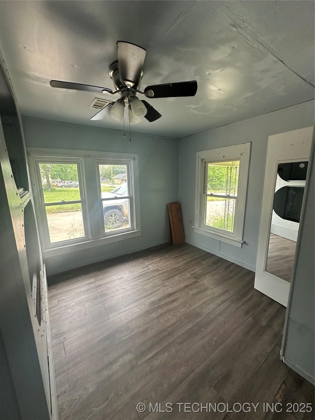 417 E SE, Ardmore, OK 73401 - empty room with dark wood-type flooring, ceiling fan, and baseboards