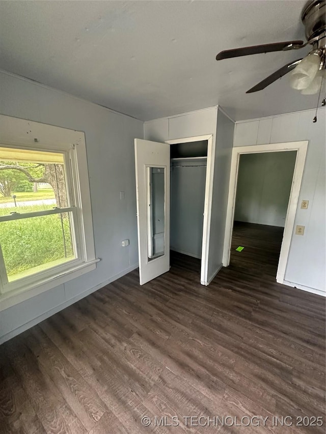 417 E SE, Ardmore, OK 73401 - unfurnished bedroom with dark wood-style flooring, a closet, a ceiling fan, and baseboards