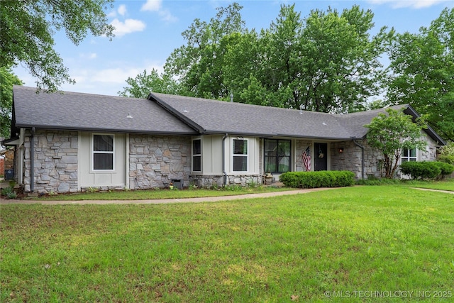 ranch-style house with a shingled roof, a front lawn, and stone siding