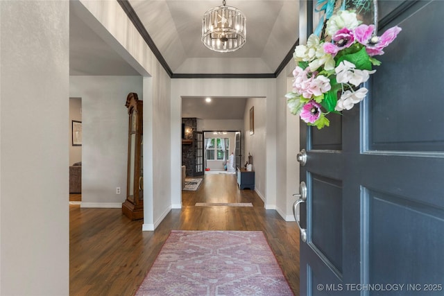 entryway featuring an inviting chandelier, baseboards, and dark wood-type flooring