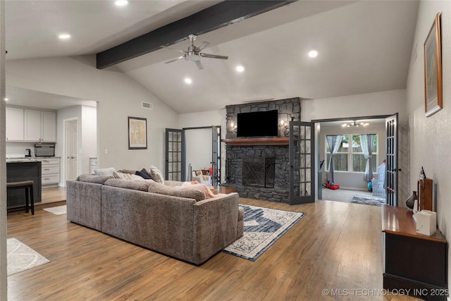 living room featuring lofted ceiling with beams, a fireplace, ceiling fan, and wood finished floors