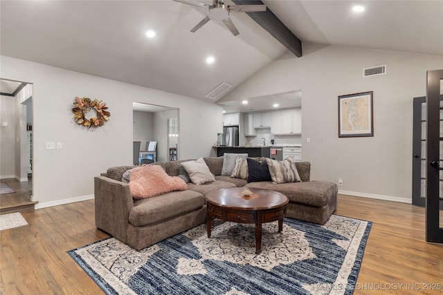 living area with light wood finished floors, beam ceiling, visible vents, and baseboards