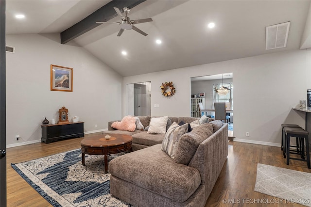 living area with lofted ceiling with beams, ceiling fan with notable chandelier, wood finished floors, visible vents, and baseboards