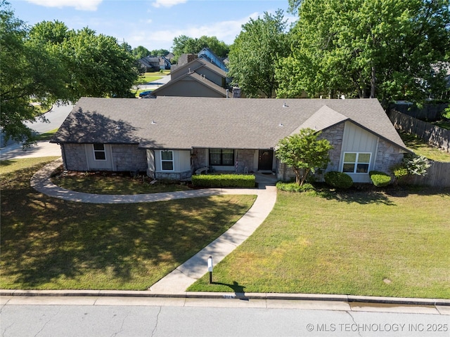 ranch-style home with stone siding, a shingled roof, fence, and a front yard