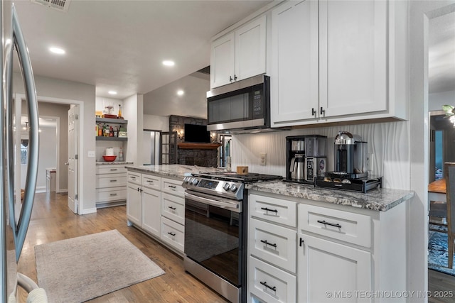 kitchen featuring recessed lighting, stainless steel appliances, white cabinets, and light wood-type flooring