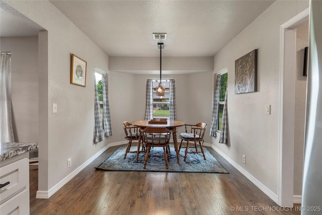 dining room featuring baseboards, visible vents, and dark wood-type flooring