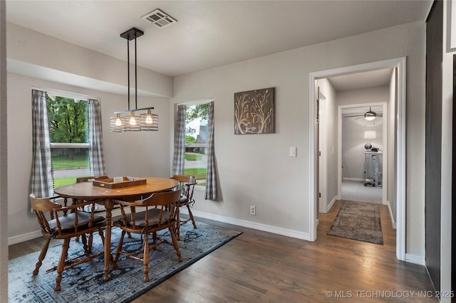 dining room with baseboards, a healthy amount of sunlight, visible vents, and dark wood-type flooring
