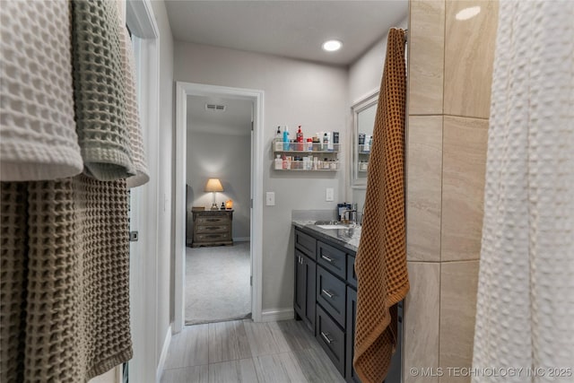 full bathroom featuring vanity, baseboards, and visible vents