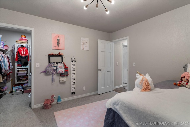 carpeted bedroom featuring a closet, baseboards, and a walk in closet