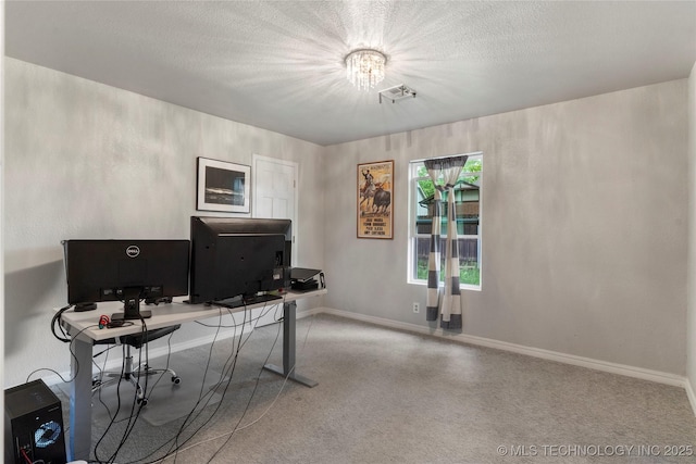 home office with a textured ceiling, visible vents, and baseboards