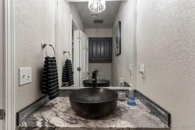 bathroom with visible vents and a textured wall