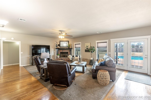 12285 N 164th E Pl, Collinsville, OK 74021 - living area featuring wood finished floors, a brick fireplace, and a ceiling fan