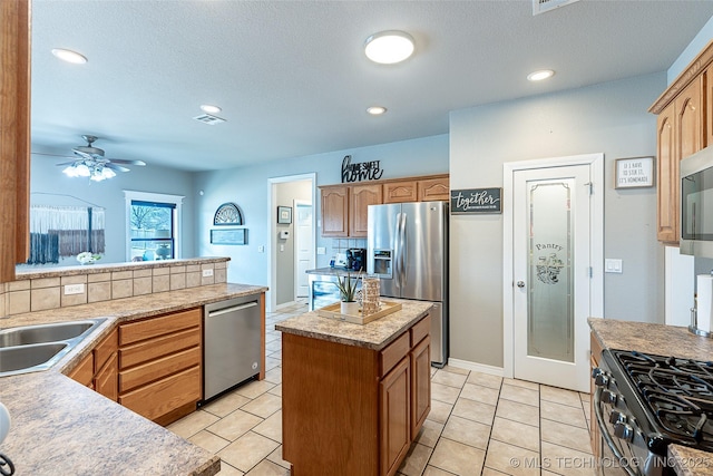 12285 N 164th E Pl, Collinsville, OK 74021 - kitchen with stainless steel appliances, decorative backsplash, light countertops, ceiling fan, and recessed lighting