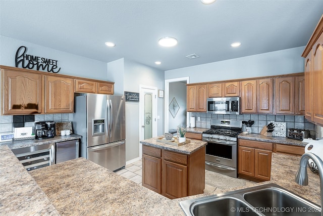 kitchen featuring backsplash, visible vents, appliances with stainless steel finishes, and a sink