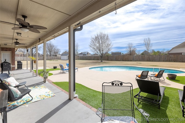 view of swimming pool with a patio, a fenced in pool, a ceiling fan, and a fenced backyard