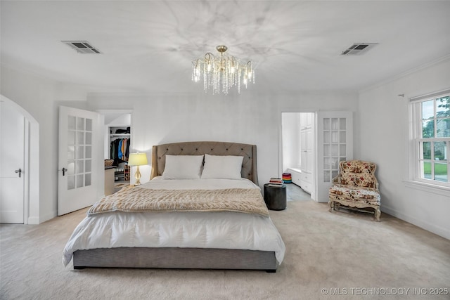 bedroom with carpet, ornamental molding, an inviting chandelier, visible vents, and arched walkways