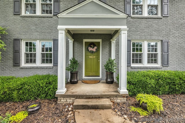 entrance to property featuring brick siding