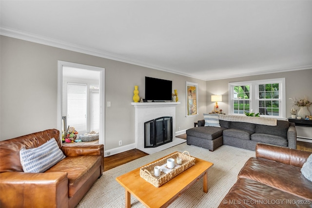 living room with baseboards, ornamental molding, a fireplace with flush hearth, and wood finished floors