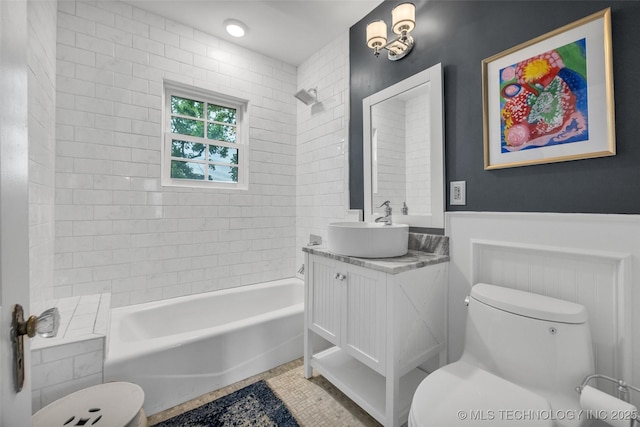 bathroom with shower / bathing tub combination, vanity, toilet, and a wainscoted wall