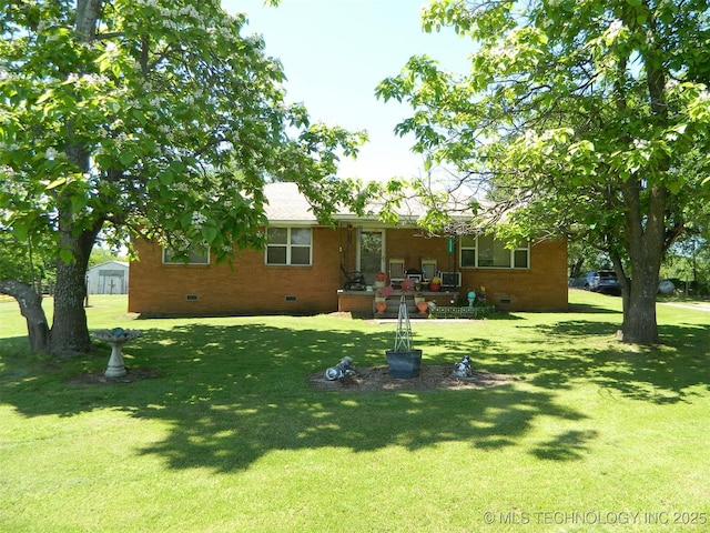 rear view of property featuring a lawn, brick siding, and crawl space