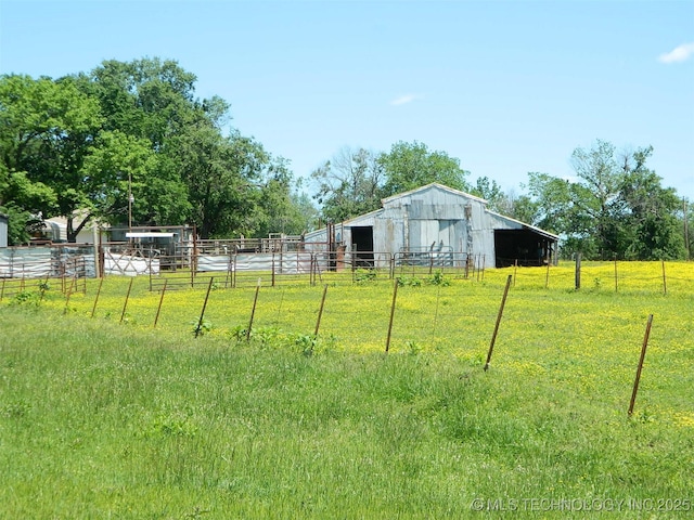 view of yard with an outdoor structure, a pole building, and fence