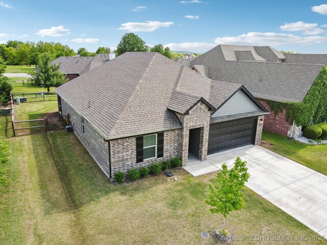 4218 W Village Park Dr, Skiatook, OK 74070 - view of front of home with fence, an attached garage, brick siding, and a front yard