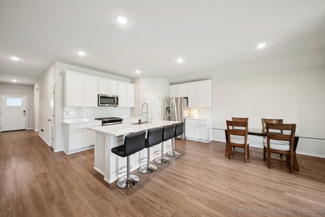 4218 W Village Park Dr, Skiatook, OK 74070 - kitchen with a sink, stainless steel appliances, light wood-style flooring, and decorative backsplash