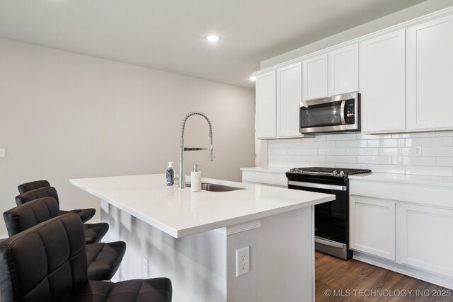 4218 W Village Park Dr, Skiatook, OK 74070 - kitchen featuring a sink, a kitchen island with sink, appliances with stainless steel finishes, decorative backsplash, and recessed lighting