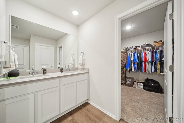 4218 W Village Park Dr, Skiatook, OK 74070 - full bath featuring a sink, double vanity, visible vents, and wood finished floors