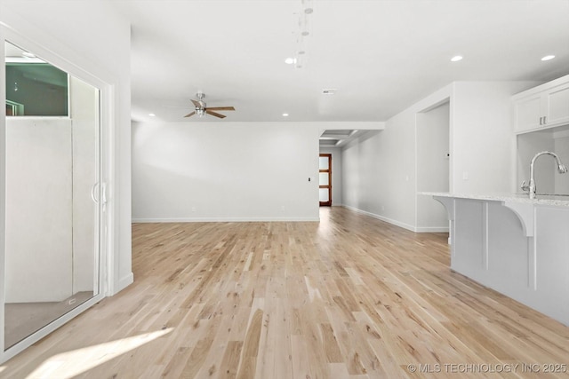 13242 E 4th Pl, Tulsa, OK 74108 - unfurnished living room with a ceiling fan, light wood-style flooring, recessed lighting, baseboards, and a sink