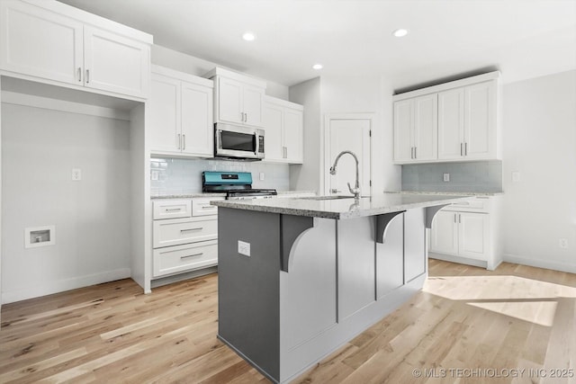 13242 E 4th Pl, Tulsa, OK 74108 - kitchen with white cabinets, appliances with stainless steel finishes, tasteful backsplash, and baseboards