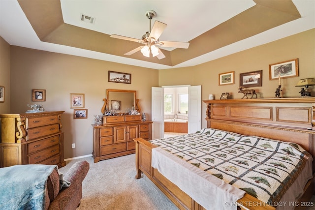 bedroom with baseboards, ceiling fan, visible vents, a raised ceiling, and light colored carpet