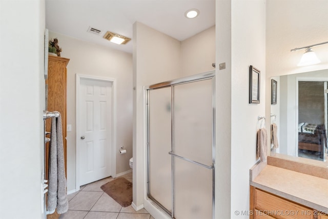 bathroom featuring toilet, visible vents, tile patterned flooring, and a shower stall