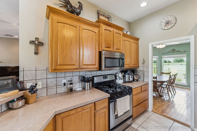 kitchen featuring stainless steel appliances, tasteful backsplash, recessed lighting, light countertops, and light tile patterned floors