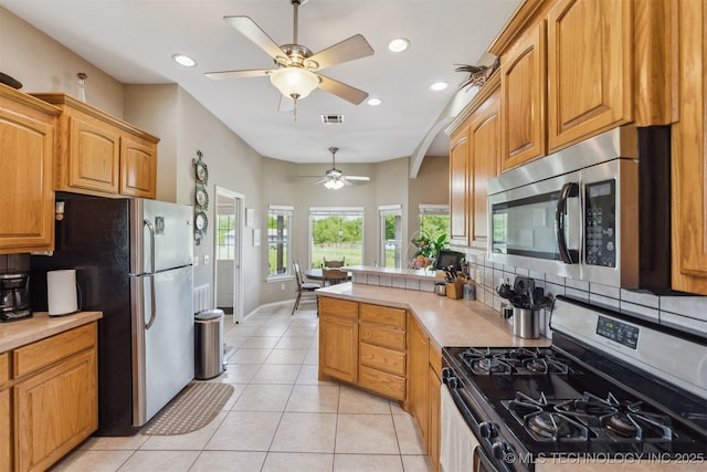 kitchen with light tile patterned floors, stainless steel appliances, visible vents, ceiling fan, and light countertops